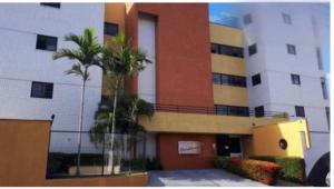 a large building with palm trees in front of it at Ap Cozy Calhau prox PRAIA in São Luís