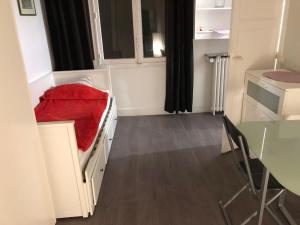 Habitación pequeña con cama con manta roja en Beau appartement,proche de métro en París