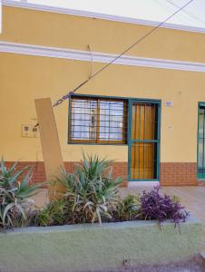 un edificio amarillo con plantas delante de él en Departamento Urquiza en San Juan