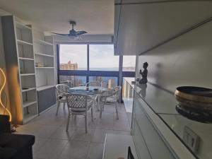 kuchnia ze stołem i krzesłami oraz dużym oknem w obiekcie APTO SM MONTECARLO P19 EDIF.GEMELOS 15 BENIDORM PLAYA LEVANTE w mieście Benidorm