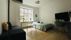 コペンハーゲンにあるApartmentInCopenhagen Apartment 1310のベッドルーム1室(ベッド1台、テーブル、窓付)