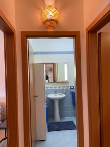 ein Badezimmer mit Waschbecken und Spiegel in der Unterkunft Belmare trilocale a piano terra indipendente in San Vito lo Capo