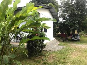 una casa blanca con un coche aparcado en el patio en Casa Girasol, en Puerto Viejo