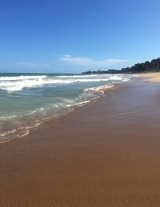 una playa con el océano y la costa en Casa do italiano, en Maceió