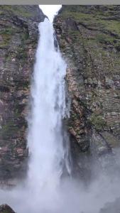 a waterfall on the side of a cliff at Pousada e Restaurante Boia Cross in Vargem Bonita