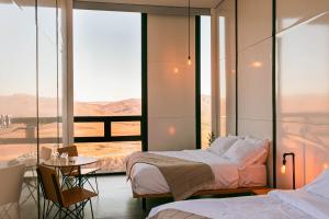 a hotel room with two beds and a view of the desert at Villa Garven in Valle de Guadalupe