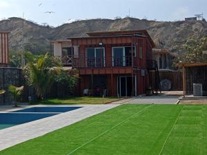 a house with a tennis court in front of a house at Hospedaje & Casa Playa AURORA in Zorritos