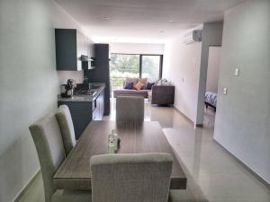 a kitchen and living room with a wooden table and chairs at Departamento Siete Loft Sábalo in Mazatlán