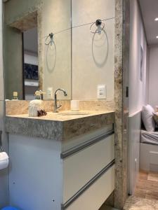 a bathroom with a sink and a mirror at STUDIOS CORACAO EUCARISTICO in Belo Horizonte