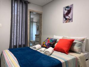 a bedroom with a bed with red and blue at STUDIOS CORACAO EUCARISTICO in Belo Horizonte