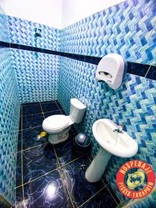 タラポトにあるHOSPEDAJE PISCIS TARAPOTOの青いタイル張りのバスルーム(トイレ、シンク付)