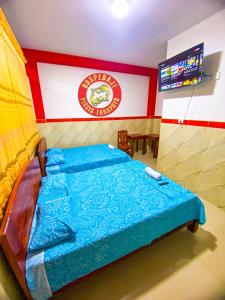 タラポトにあるHOSPEDAJE PISCIS TARAPOTOのベッドルーム1室(壁に看板付)
