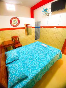 a room with a bed with a blue blanket at HOSPEDAJE PISCIS TARAPOTO in Tarapoto