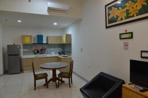 a kitchen with a table and chairs and a refrigerator at My Daily Homestay - Miri Times Square in Miri