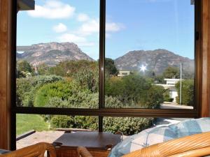 uma vista para as montanhas a partir de uma janela em Hazards House em Coles Bay