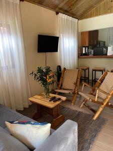 een woonkamer met een bank en stoelen en een televisie bij Hacienda La Huerta Puerto Plata, 2 BDR 