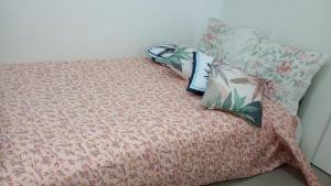a bed with pillows on top of it at Quadra Praia, Posto 4, Split, smarttv Cabo, wifi , 35m2 in Rio de Janeiro