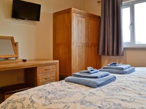 um quarto com duas toalhas azuis numa cama em Bluebell Lodge em Llandrindod Wells