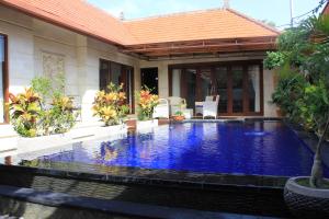 a swimming pool in front of a house at Villa Indah 2 in Sanur