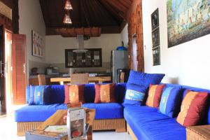 un sofá azul con almohadas coloridas en la sala de estar. en Villa Indah 2, en Sanur