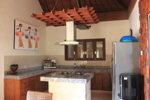 a kitchen with wooden cabinets and a refrigerator at Villa Indah 2 in Sanur