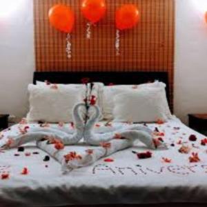 a bed with flowers on it with orange balloons at Nadi Airport Transit Hotel in Nadi