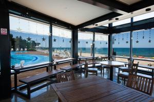 a restaurant with tables and chairs and a view of the beach at BENIKEA San&Bada Jumunjin Resort in Gangneung