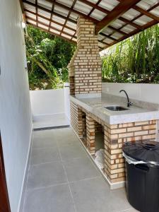 una cocina al aire libre con fregadero en un patio en Casa aconchegante Pontal do Atalaia Vista Mar, en Arraial do Cabo