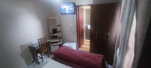 ein Wohnzimmer mit einem roten Sofa und einem TV in der Unterkunft HOTEL Rafael in Bom Retiro