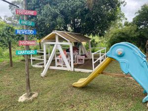 a playground with a slide and a play house at Hospedagem Recanto das Orquideas in Quatis