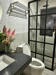 y baño con aseo y lavamanos. en Seafront OnCall - private jacuzzi with 4 cozy bedrooms, en San Juan