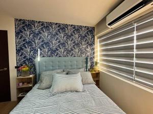 Bett mit blauem Kopfteil in einem Schlafzimmer in der Unterkunft Seafront OnCall - private jacuzzi with 4 cozy bedrooms in San Juan