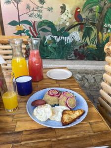 a plate of breakfast food on a wooden table at Hacienda La Huerta Puerto Plata, 1 BDR in San Felipe de Puerto Plata