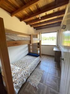 a bedroom with two bunk beds and a window at Hostel e Pousada Vale Mirante da Rocha in Timbe do Sul