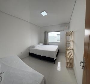 Un dormitorio con 2 camas y una escalera. en APTO NOVO TODO MOBILIADO A 400 M DA PRAIA Sensacional, en Porto Seguro