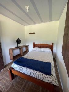 um quarto com uma cama com um cobertor azul em Hostel e Pousada Vale Mirante da Rocha em Timbe do Sul