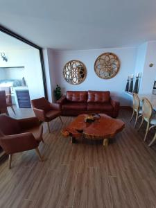 a living room with a couch and a table and chairs at Gran departamento de Lujo en primera línea en PUCON, acceso directo al Lago in Pucón