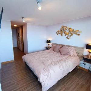 1 dormitorio con 1 cama grande y 2 lámparas en Gran departamento de Lujo en primera línea en PUCON, acceso directo al Lago, en Pucón