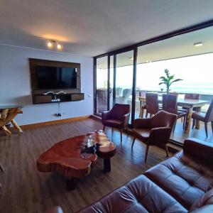 sala de estar con sofá y mesa en Gran departamento de Lujo en primera línea en PUCON, acceso directo al Lago en Pucón
