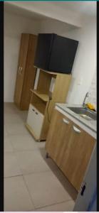 una cocina con fregadero y armarios de madera en N7 7 Habitación con Baño Privado y Kitchenette, en Montevideo
