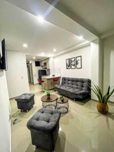 Apartamento encantador en bello(cabañas) في بيلو: غرفة معيشة بها كنب وكراسي وطاولة