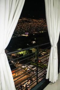 Apartamento encantador en bello(cabañas) في بيلو: منظر المدينة من النافذة ليلاً