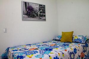Apartamento encantador en bello(cabañas) في بيلو: غرفة نوم مع سرير مع دراجة تحت الصورة