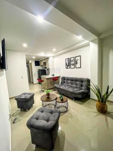 een woonkamer met banken en stoelen en een tafel bij Apartamento encantador en bello(cabañas) in Bello