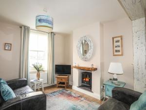 a living room with a couch and a fireplace at 14 Rose Hill in Beaumaris