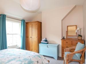 Schlafzimmer mit einem Bett, einer Kommode und einem Spiegel in der Unterkunft 14 Rose Hill in Beaumaris