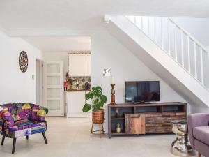 a living room with a tv and a couch at Leofric Lodge in Bampton