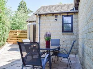 a patio with a table and chairs and a building at Leofric Lodge in Bampton
