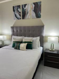 a bedroom with a bed with pillows and two lamps at Odyssey Exquisite @ Charlemont in Kingston