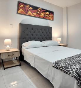1 dormitorio con 1 cama grande y 2 mesitas de noche en Acogedor Apartaestudio, en Pitalito